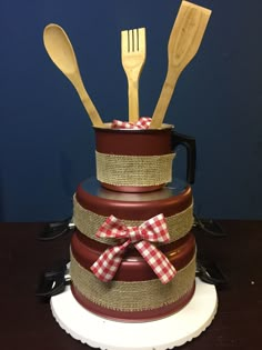 three tiered cake with wooden utensils in it