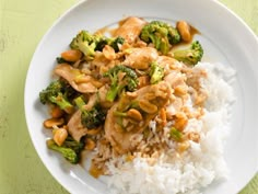 a white plate topped with rice and broccoli on top of a green table