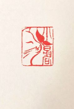 a red stamp with a cat on it's face in the middle of a piece of paper