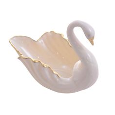 a white swan shaped bowl sitting on top of a table