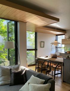 a living room filled with furniture next to a kitchen and dining room table on top of a hard wood floor