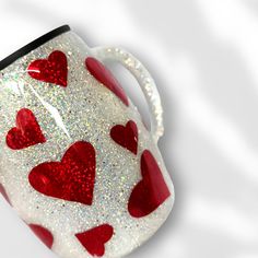 a red and white mug with hearts painted on it