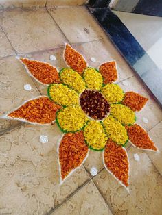 a flower made out of flowers on the ground in front of a mirror and tile floor