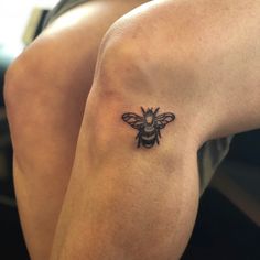 a small bee tattoo on the arm