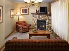 a living room filled with furniture and a fire place in front of a stone fireplace