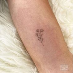 a small flower tattoo on the leg