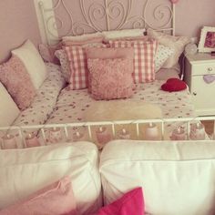 a bed with pink and white pillows on it