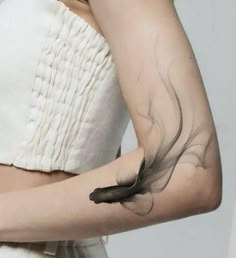 a woman with a feather tattoo on her arm