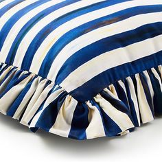 a blue and white striped pillow with ruffled edges