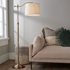 a living room scene with focus on the couch and floor lamp in the foreground