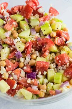 a salad with cucumber, red onion and chickpeas in a glass bowl