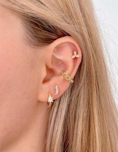 a close up of a woman's ear with three small diamond studs on it