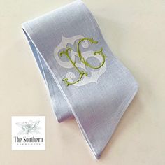 an embroidered monogrammed napkin with the letter e on it is laying on a table