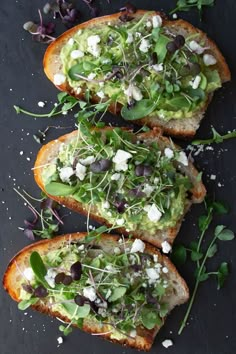 three pieces of bread topped with veggies and other toppings on a black surface