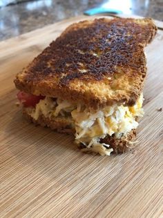 a toasted sandwich sitting on top of a wooden cutting board