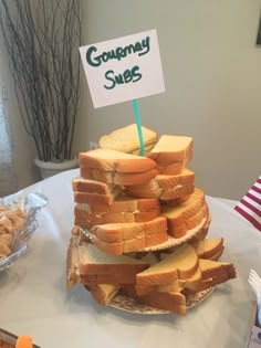 there is a very large stack of bread on the table with a sign that says gourmet sues