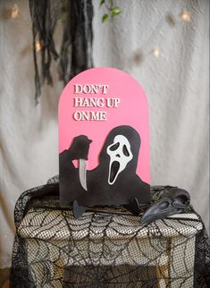 a pink sign that says don't hang up one with a black mask on it