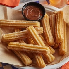 some churros are on a plate with dipping sauce