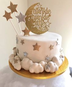 there is a white cake with gold stars on the top and sparkle twinkle little star