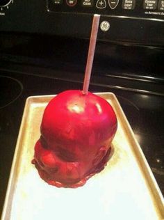 an apple that is sitting on top of a tray with a toothpick sticking out of it