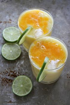 two glasses filled with orange and lime juice