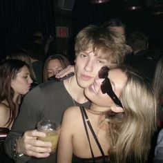 two young people are posing for the camera at a party with drinks in front of them