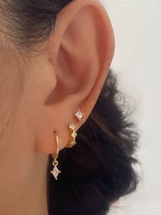 a woman's ear with three small diamonds on it