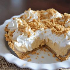 a pie with white frosting and crumbs on it sitting on a plate