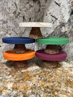 three different colored bowls stacked on top of each other in front of a stone wall