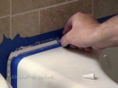 a person is cleaning a urinal with a blue and white container on the wall