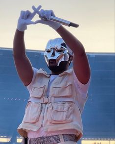 a person wearing a mask and holding a baseball bat in the air with both hands