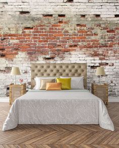 a bedroom with brick walls and white bedding in front of a wooden flooring