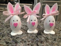 three decorated eggs sitting on top of a counter next to each other in the shape of rabbits