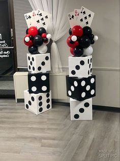 some black and white polka dot balloons are on top of each other in front of a window