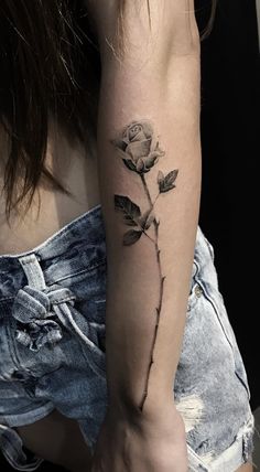 a woman with a rose tattoo on her arm