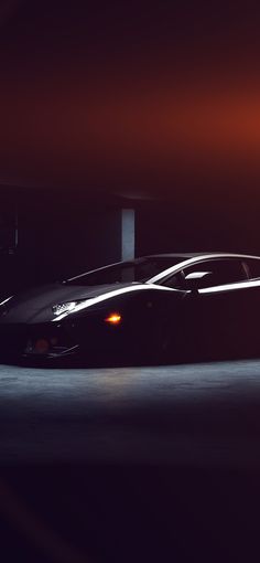 a black sports car is parked in the dark