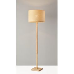 a wooden floor lamp with a beige shade on it's side and a white background