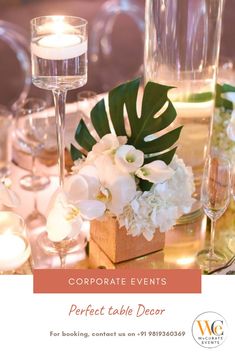 the table is set with white flowers, candles and place settings for an elegant dinner