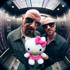 two men standing next to each other holding a hello kitty stuffed animal in front of them