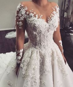 a woman wearing a wedding dress with flowers on it