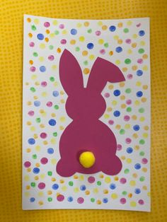 a card with a paper cut out of a bunny and a yellow ball on it