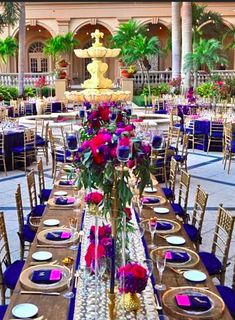 the tables are set with place settings and flowers in vases on each side of the table