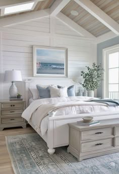 a bedroom with white walls and wooden ceilings, an area rug on top of the bed