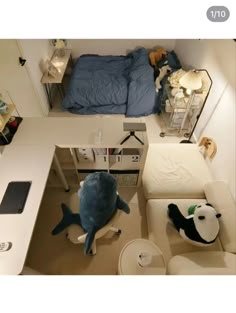 an aerial view of a bedroom with a bed, desk and stuffed animals on the floor