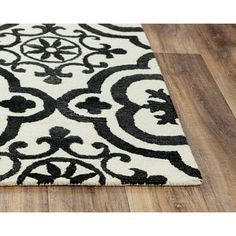 a black and white area rug on a wooden floor with wood floors in the background