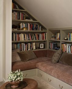 a corner couch in front of bookshelves filled with books