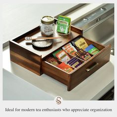 a wooden tray with teas and spices in it on top of a counter next to an oven