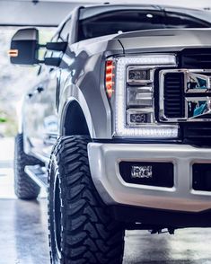 the front end of a silver truck parked in a garage