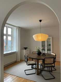 a dining room table and chairs with an arch in the middle