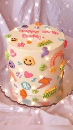 a white cake with lots of colorful decorations on it's side and lights around the edges